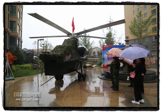 小區(qū)突然出現(xiàn)“飛機坦克”，其中殲15艦載戰(zhàn)斗機一架、99式主戰(zhàn)坦克一輛、武直-10武裝直升機一架，吸引了眾多市民雨中圍觀、合影。